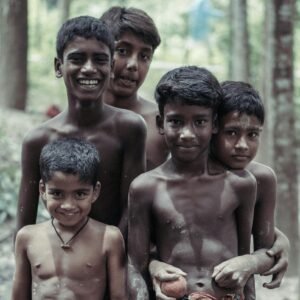 A group of five cheerful boys smiling in a lush, tropical forest setting, embracing friendship and joy.